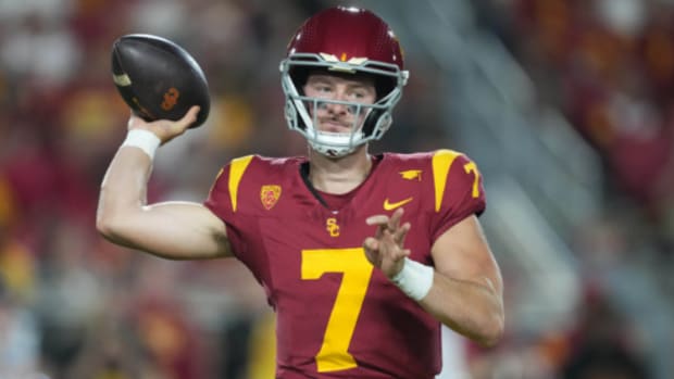 USC Trojans quarterback Miller Moss attempts a pass during a college football game.